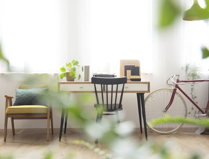 Schreibtisch aus Holz steht vor Fenster und passt sich den Platzverhältnissen an